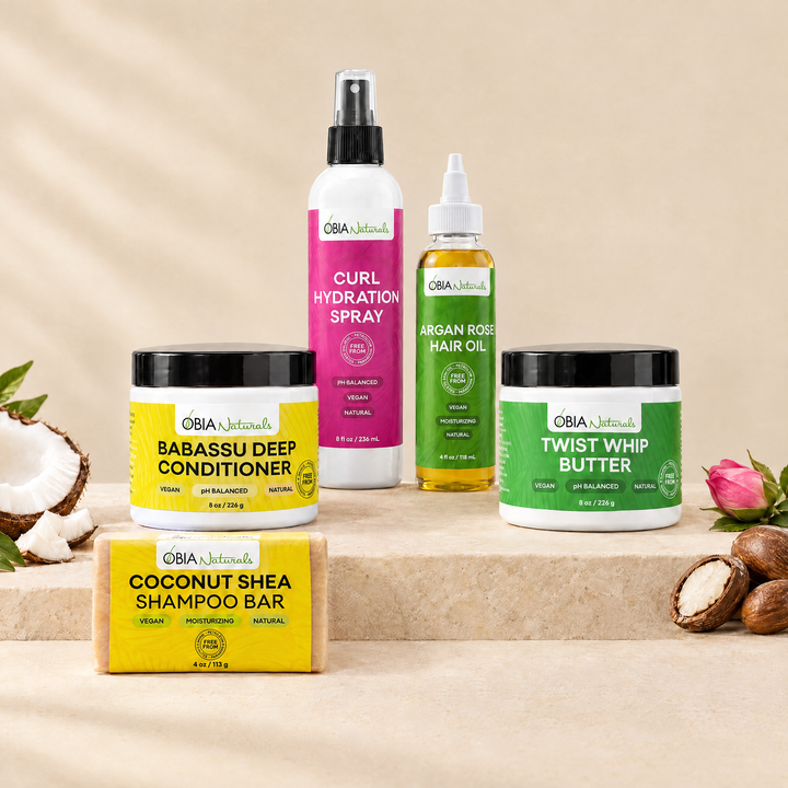 OBIA Naturals Type 4 Moisture Bundle with Coconut Shea Shampoo Bar — shampoo bar, Babassu Deep Conditioner, Curl Hydration Spray, Argan Rose Hair Oil and Twist Whip Butter arranged on a stone plinth