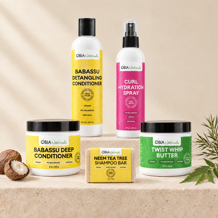 OBIA Naturals Protein-Free, Coconut-Oil-Free Hair Bundle with Twist Whip Butter — Neem Tea Tree Shampoo Bar, Babassu Deep Conditioner, Babassu Detangling Conditioner, Curl Hydration Spray and Twist Whip Butter arranged on a stone plinth
