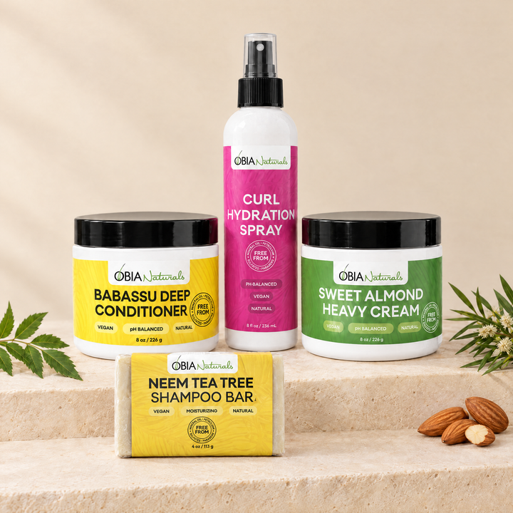 OBIA Naturals Low Porosity Hair Bundle with Neem Tea Tree Shampoo Bar — shampoo bar, Babassu Deep Conditioner, Curl Hydration Spray and Sweet Almond Heavy Cream arranged on a stone plinth
