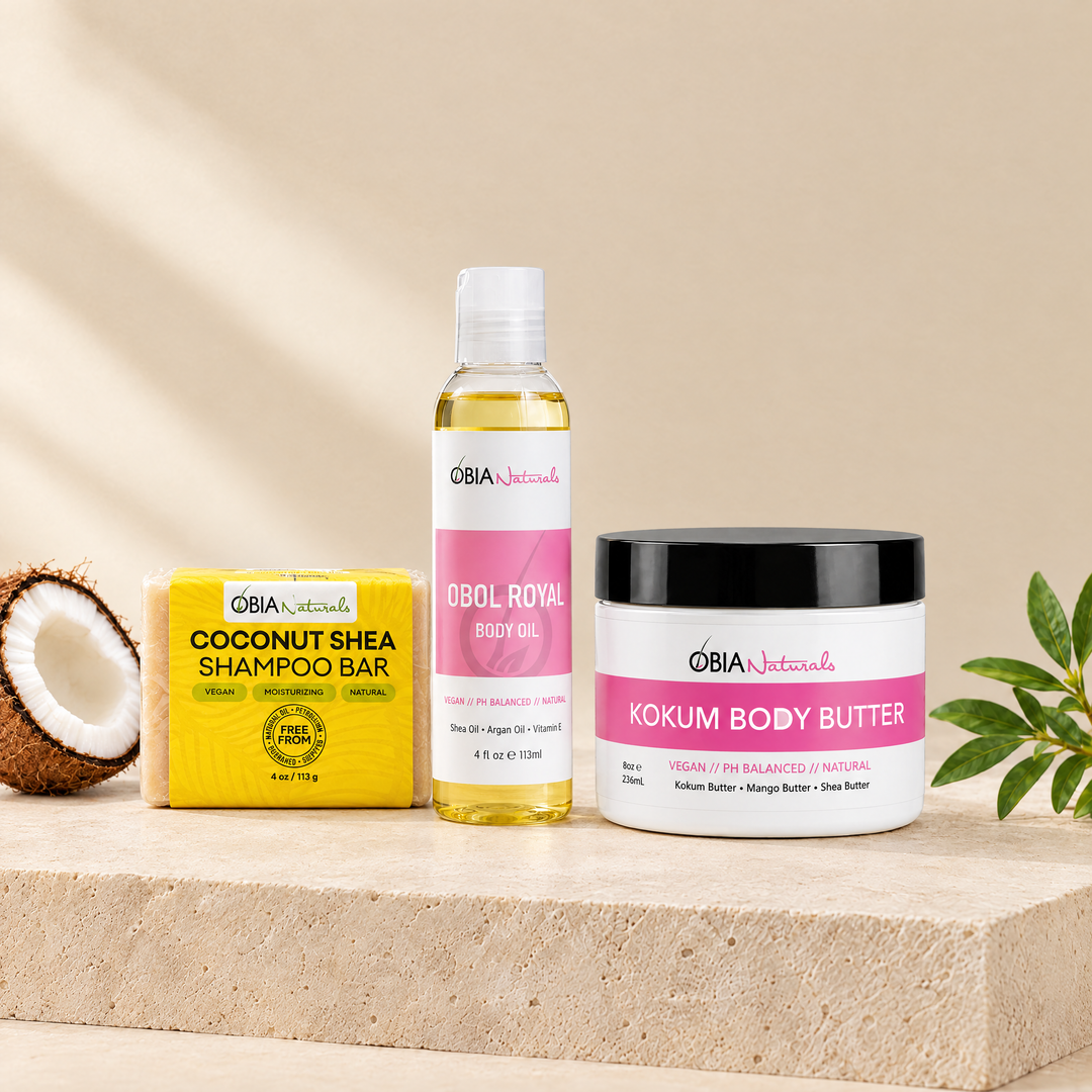 Shower to Door gift set: Coconut Shea Shampoo Bar, OBOL Royal Body Oil and Kokum Body Butter on a stone plinth